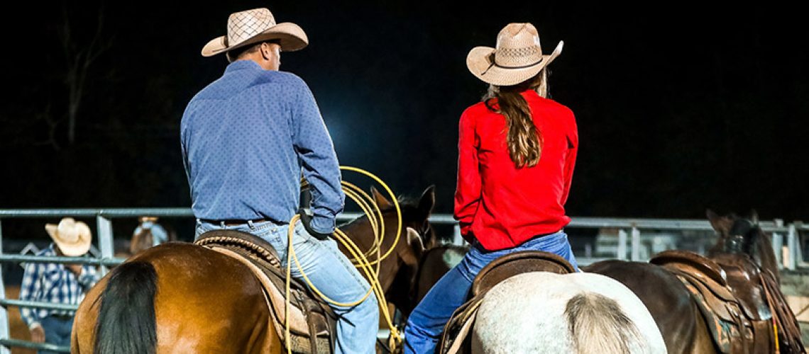 Two people on horses. Photo taken from behind.